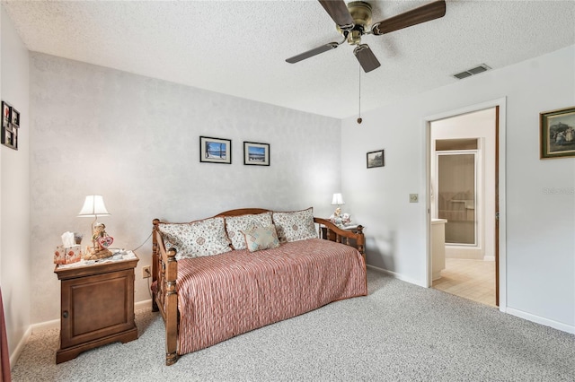 carpeted bedroom featuring ceiling fan, ensuite bathroom, and a textured ceiling