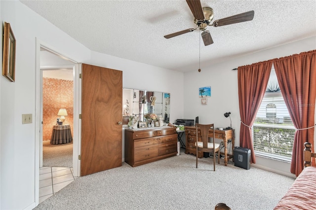 carpeted bedroom featuring ceiling fan and a textured ceiling