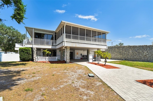 rear view of house featuring a carport and a sunroom