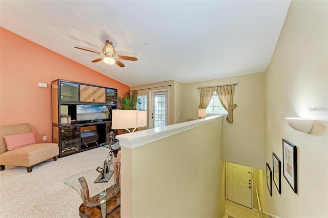 living room featuring lofted ceiling, ceiling fan, and carpet flooring