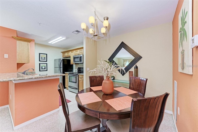 dining room featuring sink and a notable chandelier