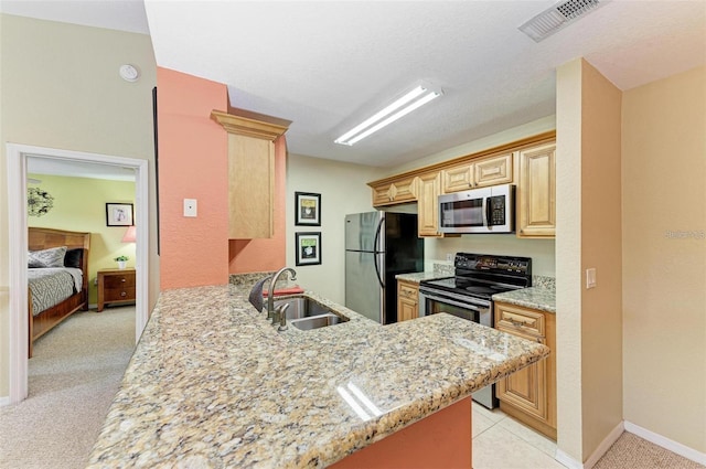 kitchen with light brown cabinetry, sink, stainless steel appliances, and kitchen peninsula