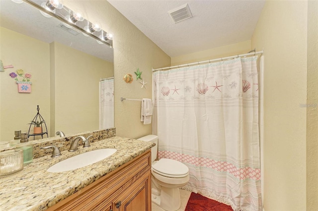 bathroom featuring vanity, toilet, and a textured ceiling