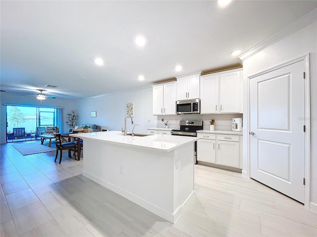 kitchen featuring white cabinetry, sink, an island with sink, and appliances with stainless steel finishes