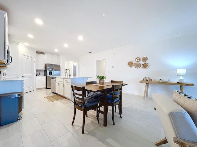 dining area with sink and crown molding