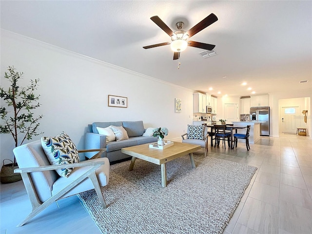 living room featuring light tile patterned flooring, ceiling fan, and ornamental molding