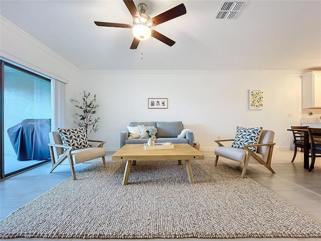 living room featuring ornamental molding, light hardwood / wood-style floors, and ceiling fan