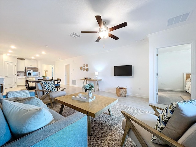 living room featuring light hardwood / wood-style floors and ceiling fan