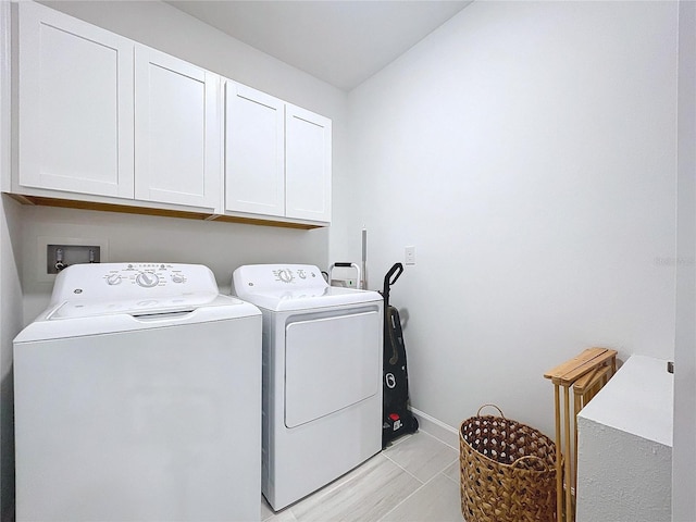 washroom featuring cabinets and independent washer and dryer