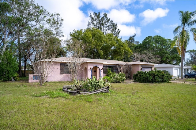 ranch-style home featuring a garage and a front lawn