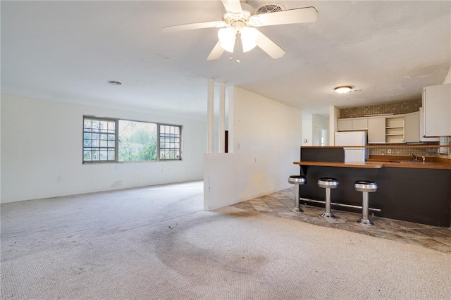 carpeted living room with ceiling fan