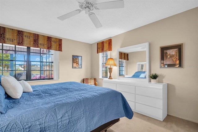 bedroom featuring light colored carpet and ceiling fan