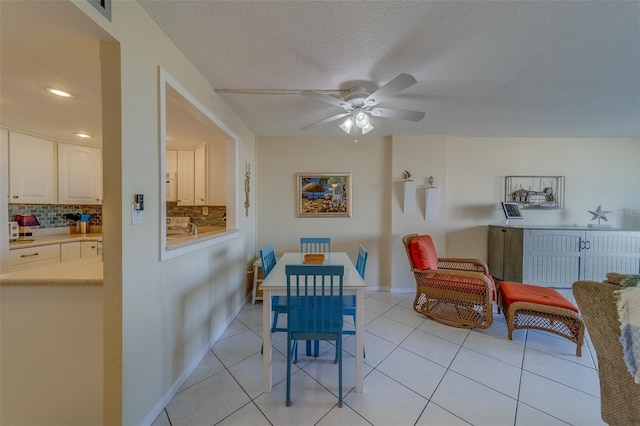 dining room featuring light tile patterned flooring, a textured ceiling, and ceiling fan