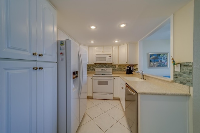 kitchen with white cabinetry, sink, decorative backsplash, light tile patterned floors, and white appliances