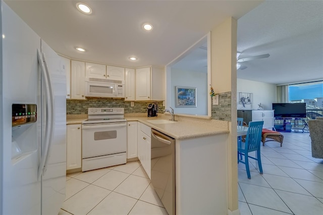 kitchen featuring sink, tasteful backsplash, light tile patterned floors, white appliances, and white cabinets