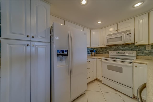 kitchen with white appliances, decorative backsplash, white cabinets, and light tile patterned flooring