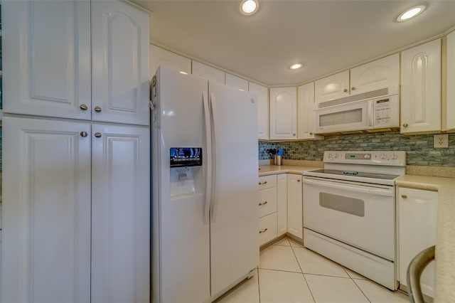 kitchen featuring light tile patterned floors, white appliances, decorative backsplash, and white cabinets