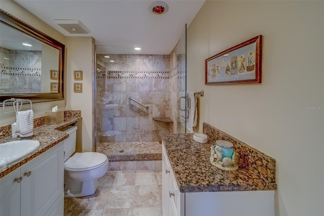 bathroom with vanity, a shower with shower door, and toilet