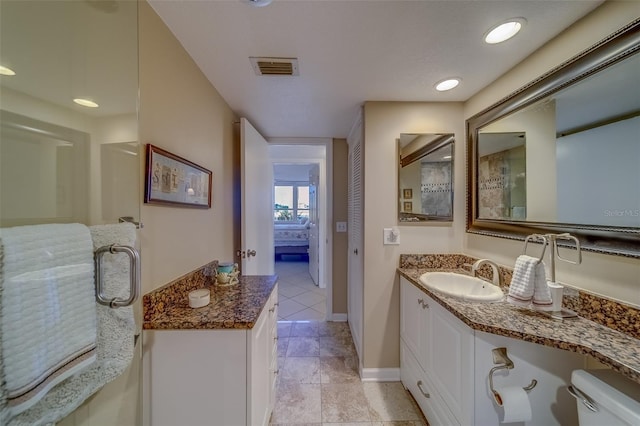 bathroom featuring vanity, tile patterned floors, and toilet