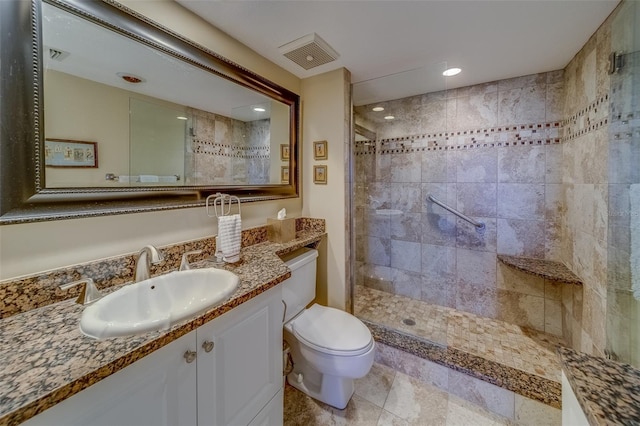 bathroom featuring vanity, toilet, and tiled shower