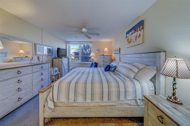 bedroom with ceiling fan and dark carpet