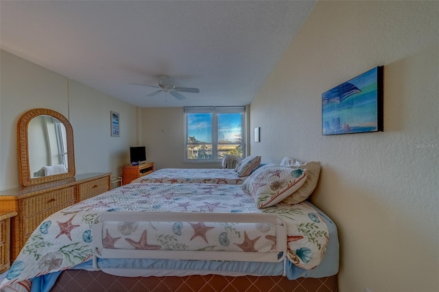 bedroom featuring ceiling fan and a textured ceiling