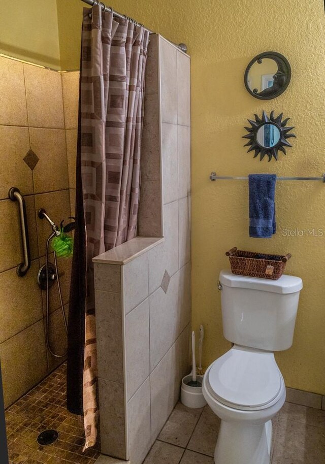 bathroom featuring tile patterned flooring, toilet, and a shower with shower curtain