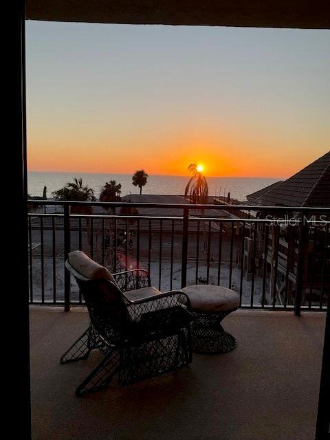 patio terrace at dusk with a water view and a balcony