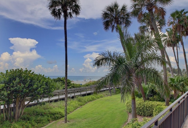 surrounding community featuring a water view and a lawn