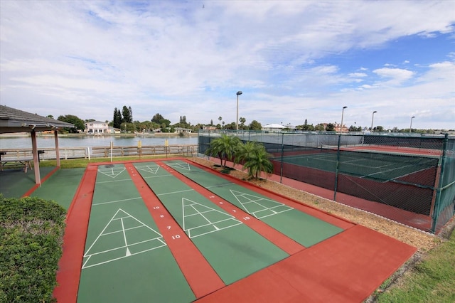 view of property's community featuring tennis court and a water view