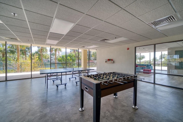 playroom featuring a paneled ceiling and floor to ceiling windows