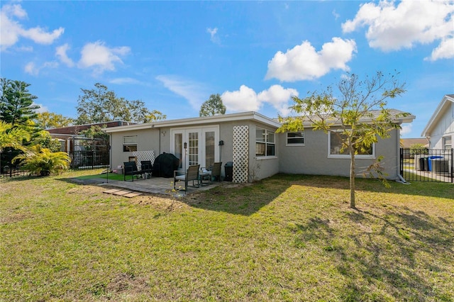 rear view of house with french doors, a yard, and a patio area