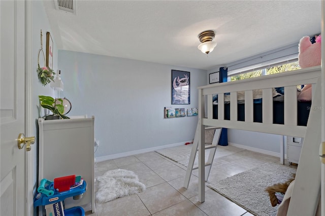 tiled bedroom with a textured ceiling