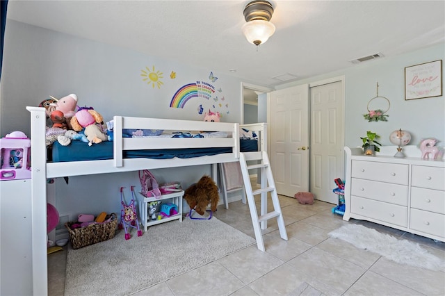 bedroom featuring light tile patterned floors and a closet