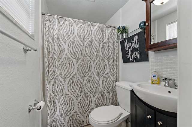 bathroom with vanity, backsplash, a textured ceiling, and toilet