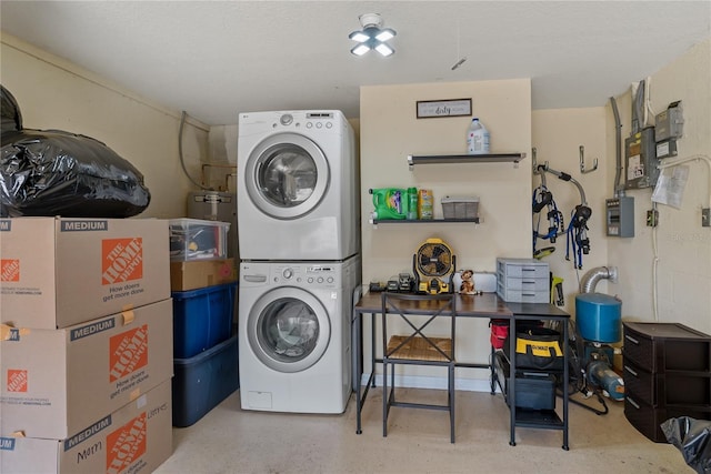 clothes washing area featuring stacked washer and clothes dryer and electric panel