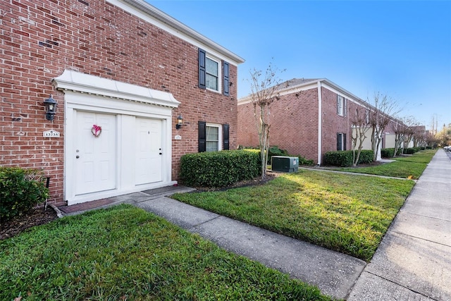 exterior space featuring central AC unit and a front lawn