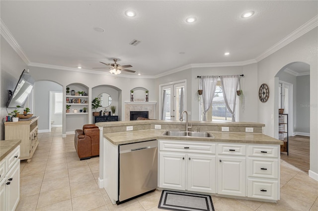 kitchen with stainless steel dishwasher, sink, a center island with sink, and white cabinets