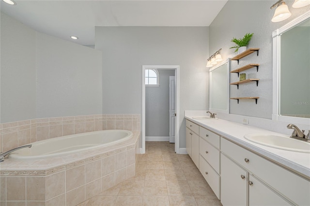 bathroom featuring tile patterned flooring, vanity, and tiled bath