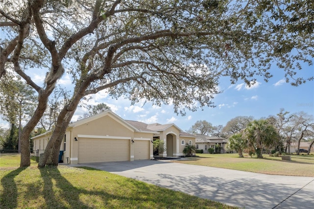 ranch-style home with an attached garage, fence, driveway, stucco siding, and a front lawn