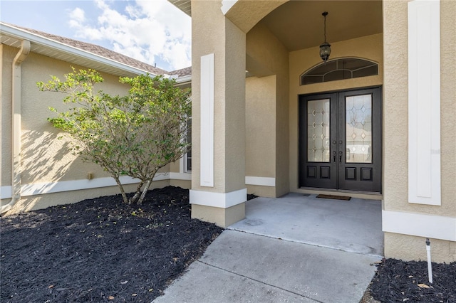 property entrance featuring french doors and stucco siding