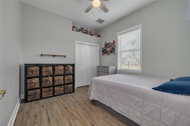 bedroom with baseboards, visible vents, a ceiling fan, wood finished floors, and a closet