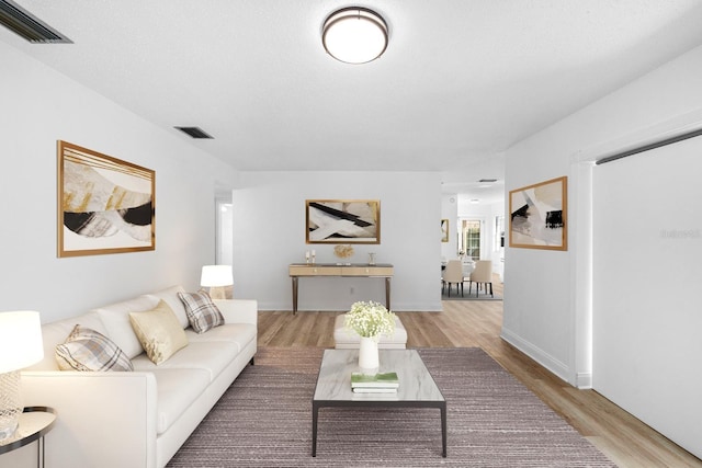 living room with light wood finished floors and visible vents