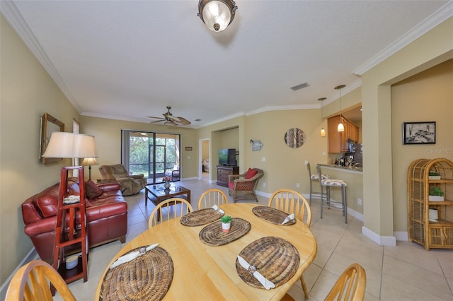 tiled dining space with crown molding and ceiling fan