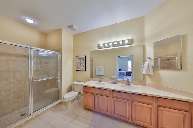 bathroom featuring vanity, a shower with shower door, tile patterned floors, and toilet