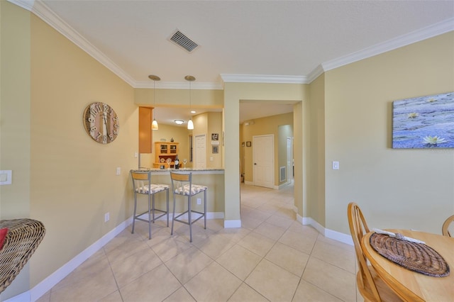 kitchen with crown molding, decorative light fixtures, a kitchen bar, and kitchen peninsula