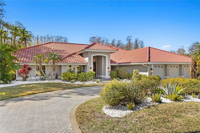 mediterranean / spanish-style house with a garage and a front yard