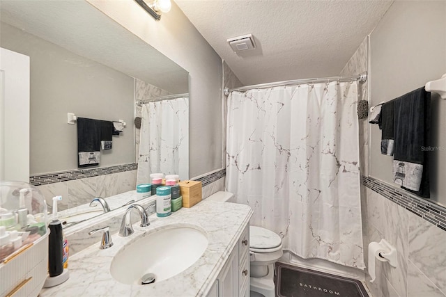 10944 Keys Gate Dr, Riverview, FL 33579 - bathroom featuring vanity, toilet, tile walls, and a textured ceiling