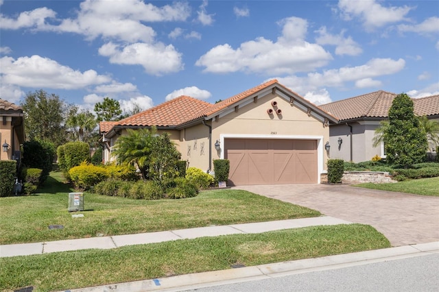 mediterranean / spanish-style house featuring a front yard and a garage