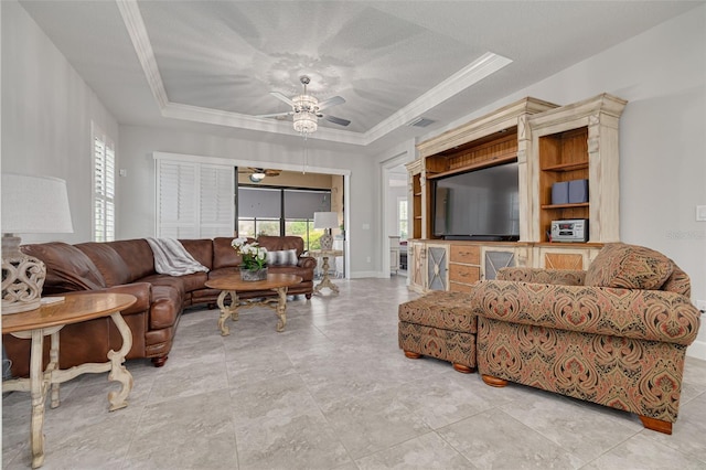 living room featuring a raised ceiling, a healthy amount of sunlight, ceiling fan, and ornamental molding